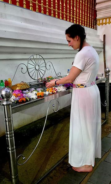 Annika Brüggemann legt Blumen an einem Tempelaltar nieder