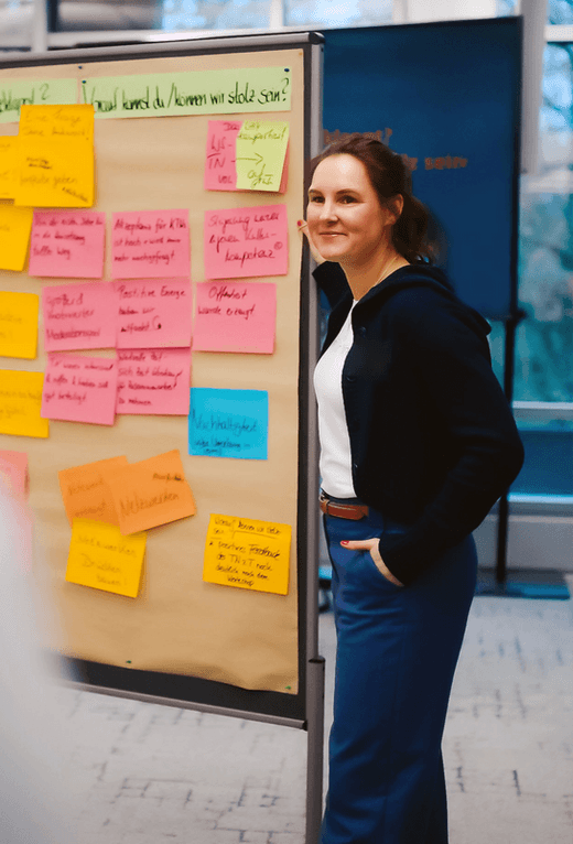 Annika Brüggemann vor einer Metaplanwand mit bunten Moderationskarten