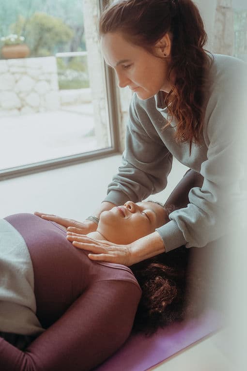 Annika Brüggemann begleitet eine liegende Person bei einer Breathwork-Session